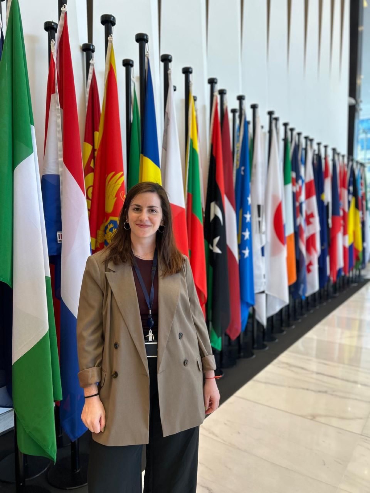 Daniela Schneider frente a una fila de banderas internacionales