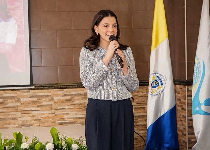 Gisselle Wolozny hablando en un acto junto a banderas