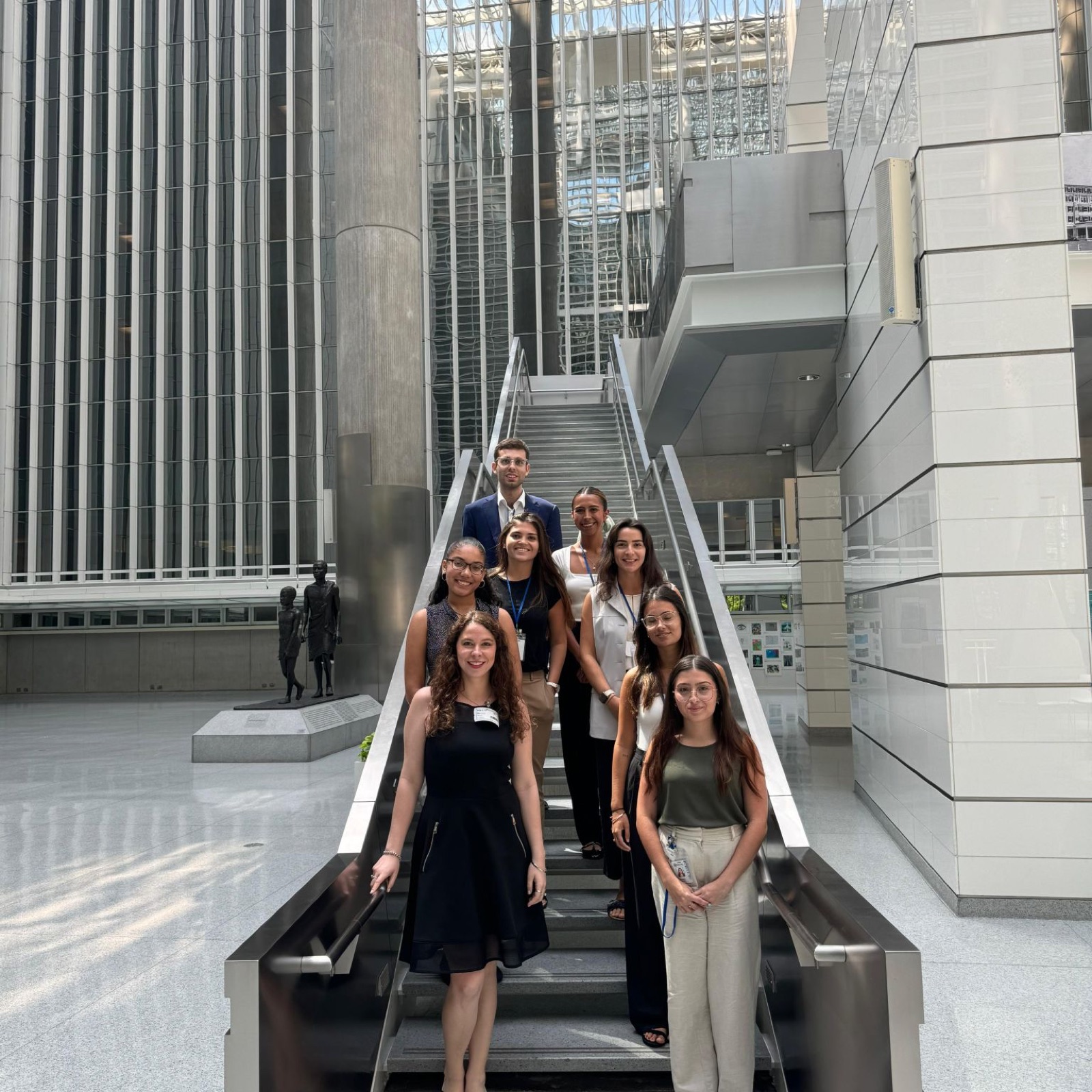 Un grupo de estudiantes en la escalinata de un edificio institucional
